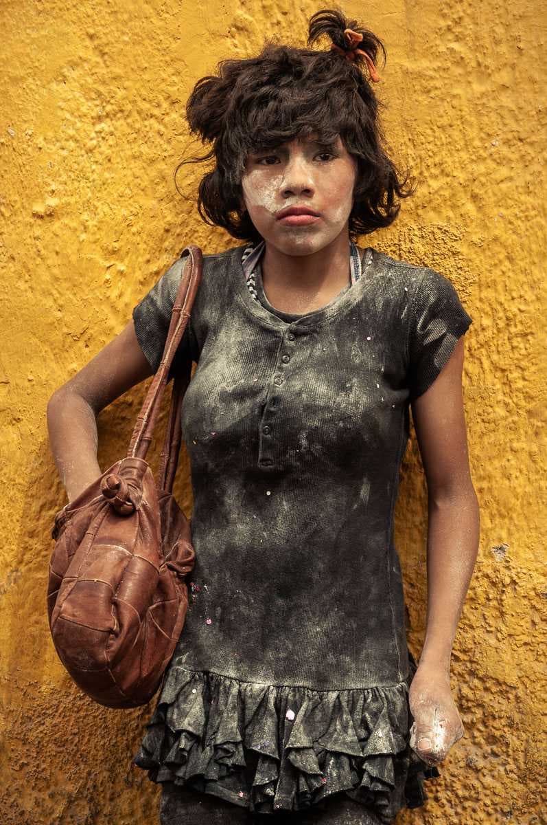 This boy's mask wouldn't stay on, so he took it off. With a fist full of flour, and his other hand stuffed into his flour-filled purse ready as a backup, he's eyeing a girl across the street that he'd like to engage next.