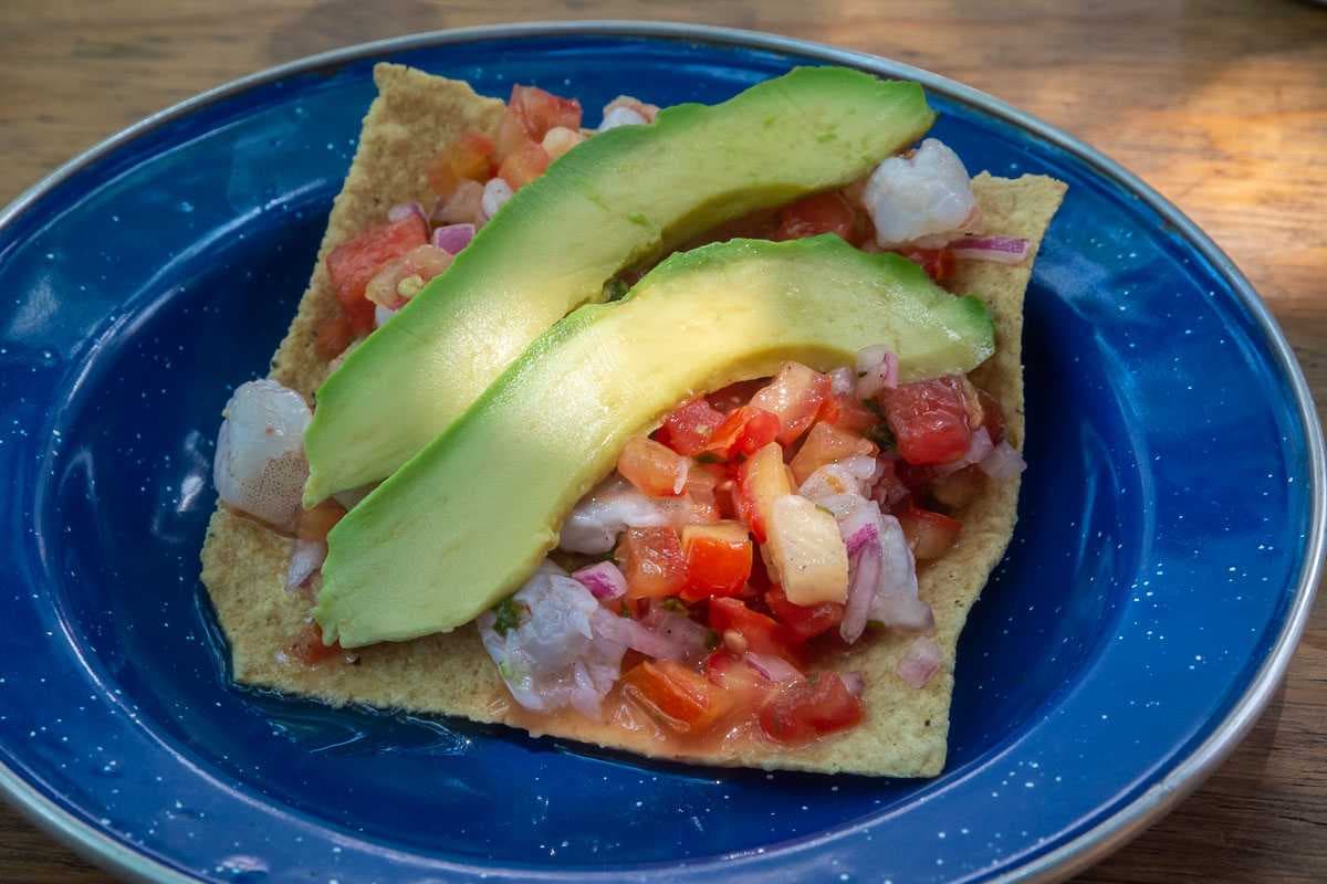 A tostada with shrimp ceviche, pico de gallo salsa, and avocado.