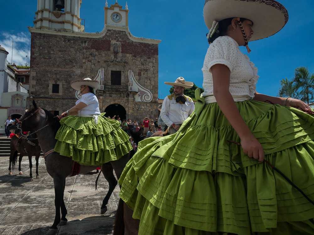 Escaramuzas Minnie Klein and her daughter, Talea, ride their horses on the atrium of San Andrés Church on el Día del Charro.