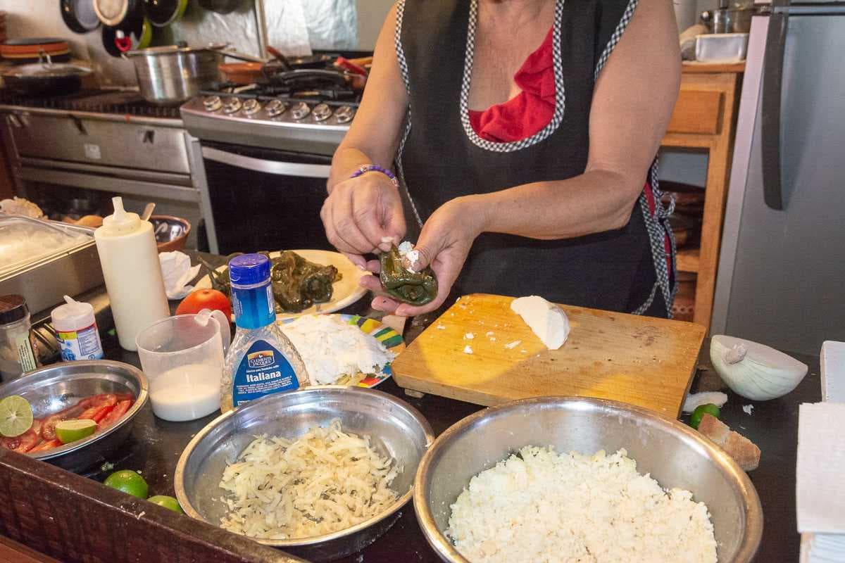 Mary prepares a chile relleno, which is a poblano pepper that's stuffed with cheese, then breaded and deep fried.