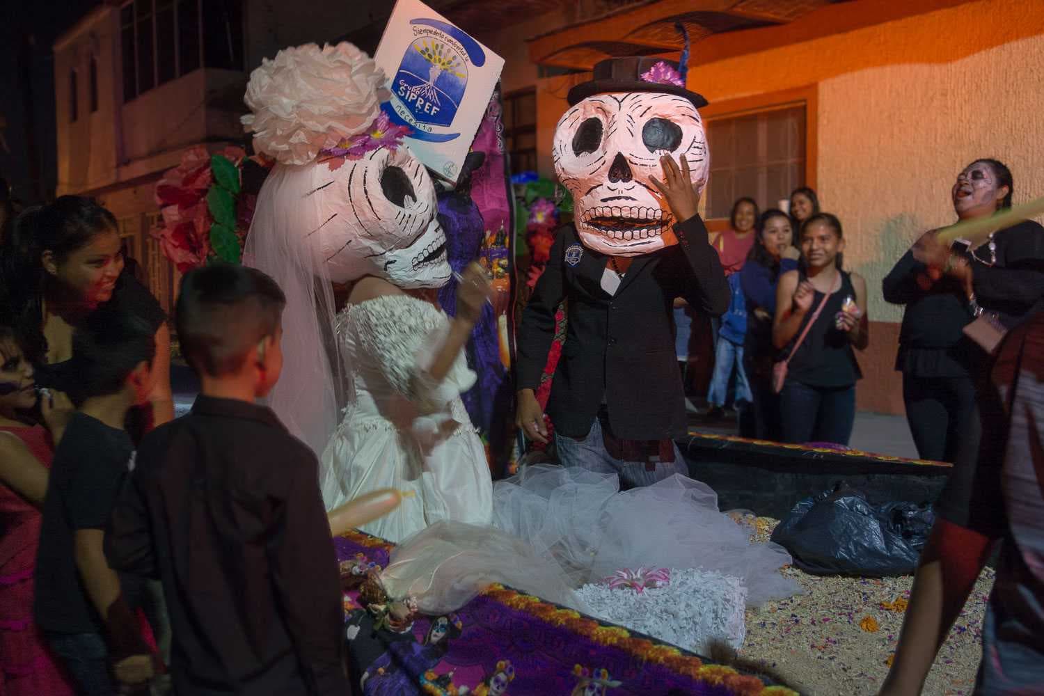 A skeleton couple ride on a float during the Day of the Dead parade in Ixtlahuacán.